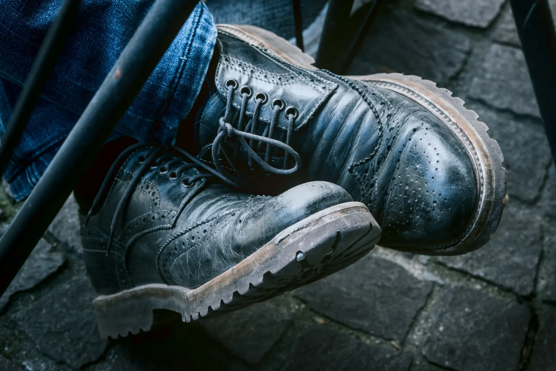 Close-up of black leather brogue boots with a lug sole